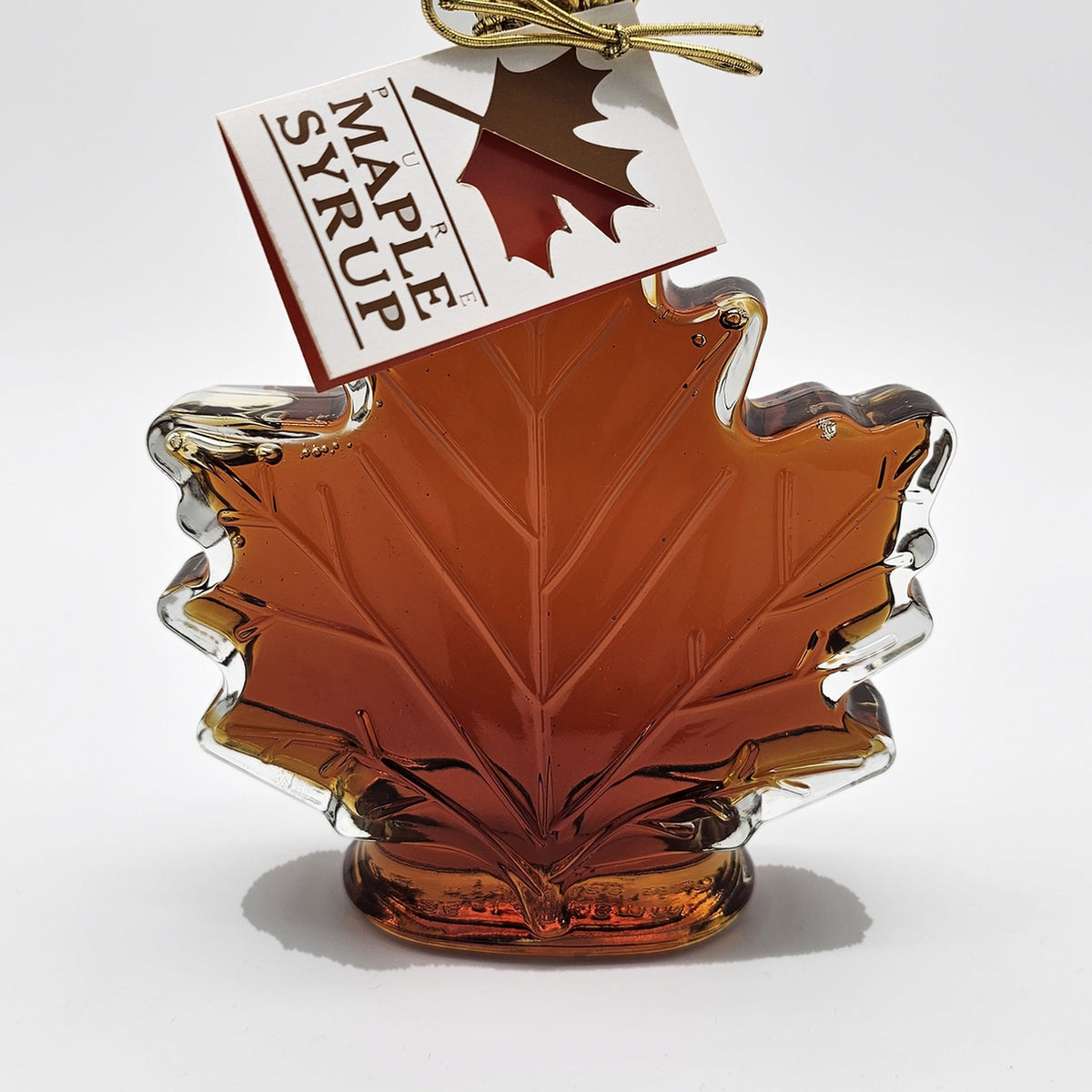 Glass maple leaf bottle of pure maple syrup with gold foil top and gift tag
