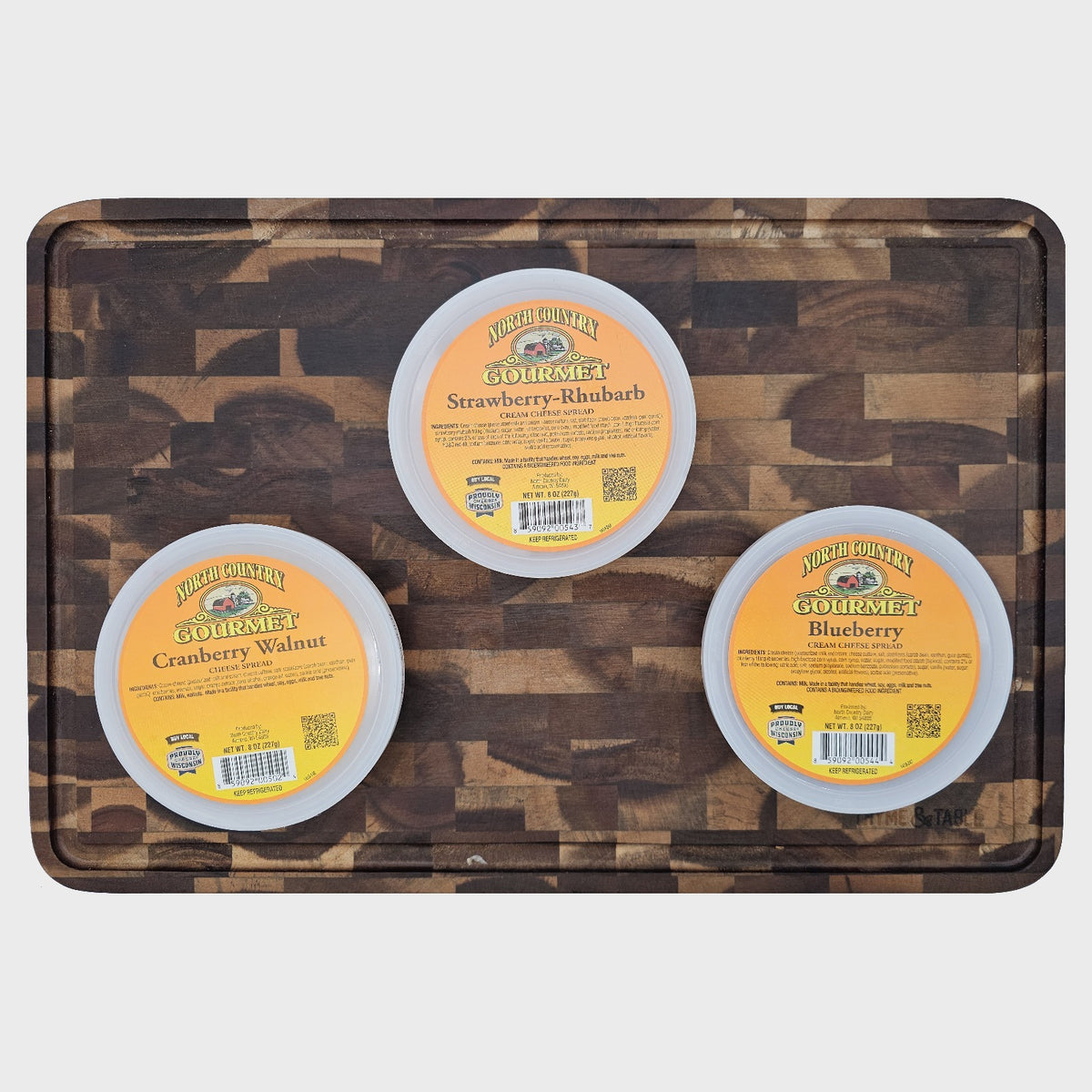 Blueberry, Strawberry Rhubarb and Cranberry Walnut cream cheese spreads on a cutting board